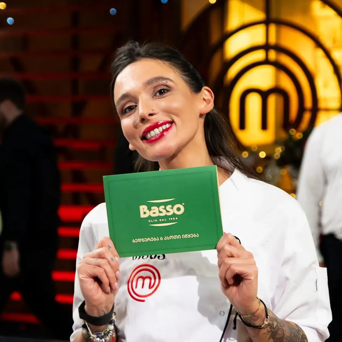 A MasterChef Georgia contestant holding a Basso card